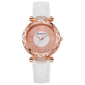 Detail of rose gold quartz watch featuring Roman numerals and sparkling rhinestone bezel