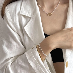 Close-up of interlocking gold and silver geometric rings on minimalist link bracelets