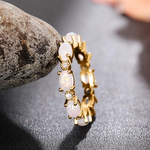 Bague empilable dorée avec opale de feu blanche et zircone sur fond de pierre grise