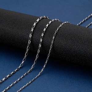 Close-up of polished silver stainless steel box chains on a professional display stand