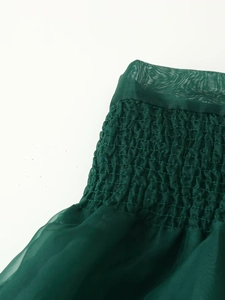 Detailansicht aus dunkelgrünem Organza mit elastischer Kräuselung und Netzgewebetextur