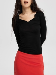 Detail of slim fit black long sleeve knit top featuring a stylish small slit V-neckline