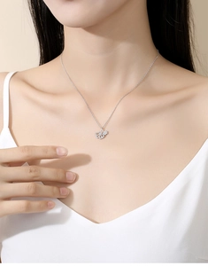 Detail view of a silver ginkgo leaf necklace pendant featuring fine diamond settings