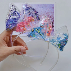 Detailed view of PVC headbands with colorful sequins and fruit slices inside bows