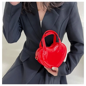 Close-up of red heart-shaped jelly handbag with glossy finish and gold zipper details