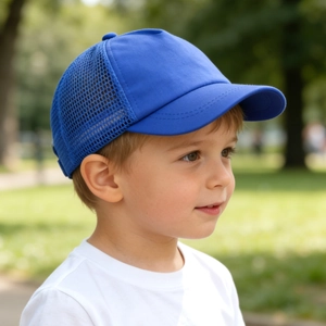Ein kleiner Junge trägt eine leuchtend blaue Mesh-Sonnenkappe in einem sonnigen Park.