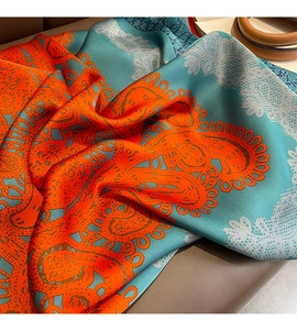 Gros plan d'un foulard en soie aux motifs paisley complexes bleu et orange