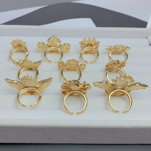 Detailed close-up of gold plated winged heart rings with red enamel in a jewelry tray