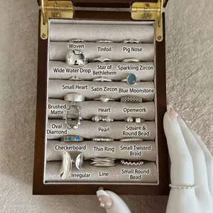 Collection of S925 sterling silver rings in various styles on a wooden display tray