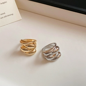 Detailed view of wave texture rings in polished gold and silver metallic finishes