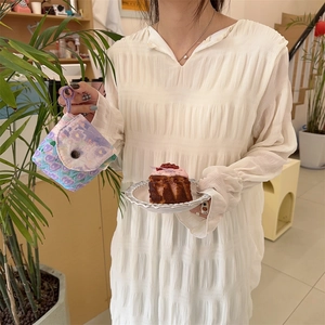 Close-up of a floral sanitary napkin pouch with lavender print held by a model