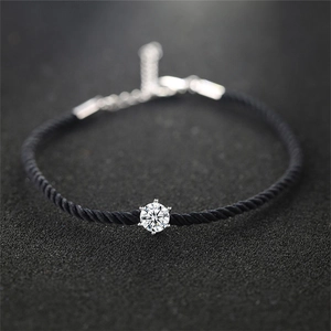 Macro shot of minimalist black rope bracelet with six-prong set cubic zirconia stone