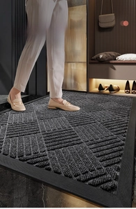 Macro detail of dark grey polypropylene entrance mat with non-slip rubber border and texture