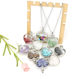 Polished silver heart pendants filled with colorful natural crystal stones on white background