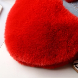 Macro view of soft red faux fur heart bag showing dense plush texture and vibrant color
