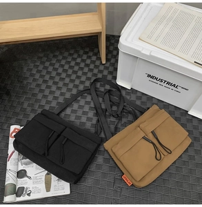 Detailed shot of black and khaki nylon crossbody bags with drawstring utility pockets