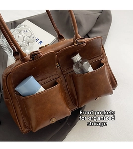 Detail of vintage brown leather handbag featuring dual front flap pockets for storage