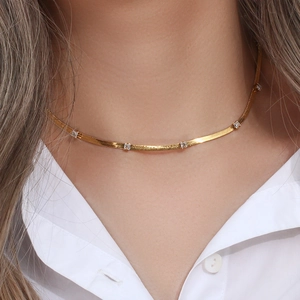 Close-up of gold blade chain necklace with square cubic zirconia on a model's neck