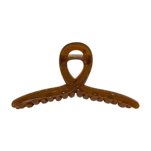 Pince à cheveux élégante en résine ambrée avec design croisé sur fond blanc éclatant