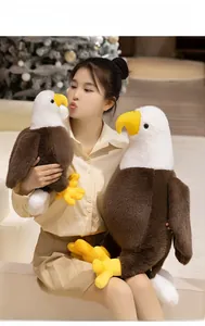 Detail view of large and medium bald eagle plush toys held by model for size comparison