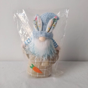 Detail of Easter gnome plush with blue knit hat, bunny ears and carrot decoration