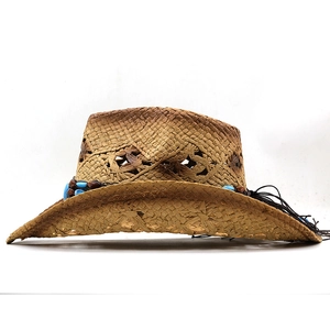 Close-up of woven straw cowboy hat with blue beaded trim and hollow texture details