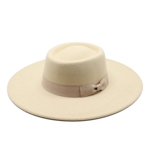 Beige wide brim wool fedora hat with a matching satin ribbon bow on white background