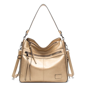 Detail of gold metallic tote bag with lychee texture and stylish dual tassel zippers