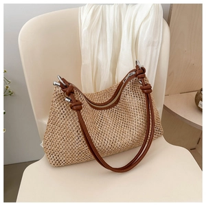 Close-up of woven straw texture and dark brown leather strap with metal buckle