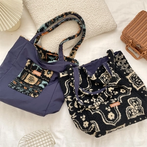 Detail of two plush canvas tote bags featuring ethnic patterns and brand leather tags