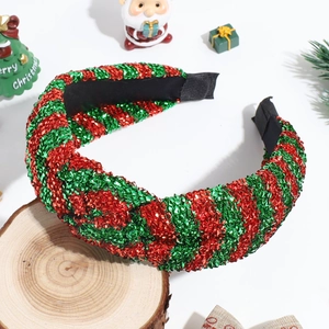 Detail of red and green sequined knotted headband on wood with Christmas decor background