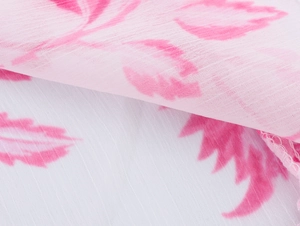 Gros plan sur le tissu mousseline blanc à fleurs avec imprimé rose et ourlets délicats