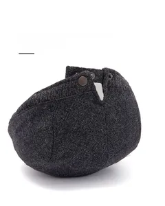 Detailed view of adjustable stainless steel metal buckle on dark grey wool newsboy cap