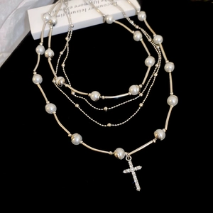 Multi-layer pearl necklace with silver metal tubes and a crystal cross pendant