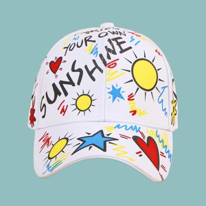 Détail de la casquette blanche avec motifs graffiti colorés de cœurs et de soleils