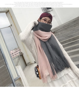 Detail shot of a thick grey and pink color-block knitted scarf with fringe on a model