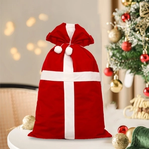 Red flocked Christmas gift bag with white plush balls and festive holiday decorations