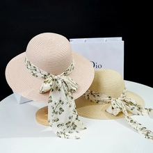 Detail view of woven straw hats with floral chiffon ribbons and elegant bows