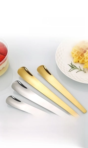 Detailansicht langer Dessertlöffel aus Edelstahl in Gold und Silber auf dem Tisch