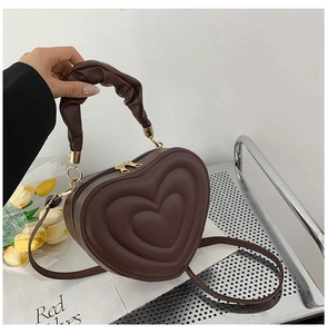 Detail of a dark brown heart-shaped bag with concentric embossed patterns and ruched handle