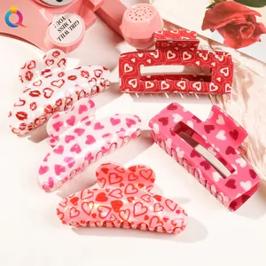 Set of pink acrylic Valentine hair clips with heart and lip prints on a floral backdrop
