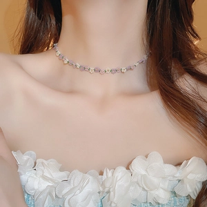 Close-up of pastel floral seed bead necklace with pink and white flower charms