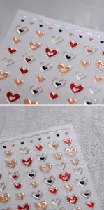 Macro view of 3D embossed heart nail stickers with gold edging and vibrant colors