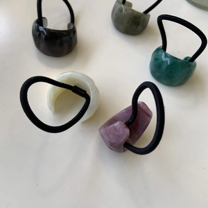 Detail of colorful resin hair ties showing five different shades with elastic bands