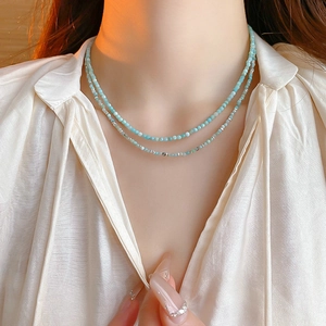 Close-up of double-layer necklace with light blue beads and silver accents on neck