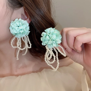 Detailed view of mint green fabric flower earrings with elegant white pearl tassels