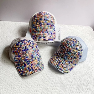 Detailed view of colorful pearls and rhinestones on stylish baseball caps for women