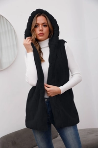 Close-up of stylish black hooded faux fur vest paired with white sweater and blue jeans