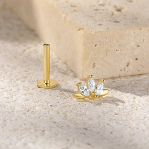 Macro view of gold S925 silver stud earring with marquise crystals on textured stone