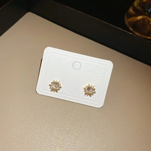 Close-up of gold snowflake stud earrings with sparkling round zircon on champagne leather